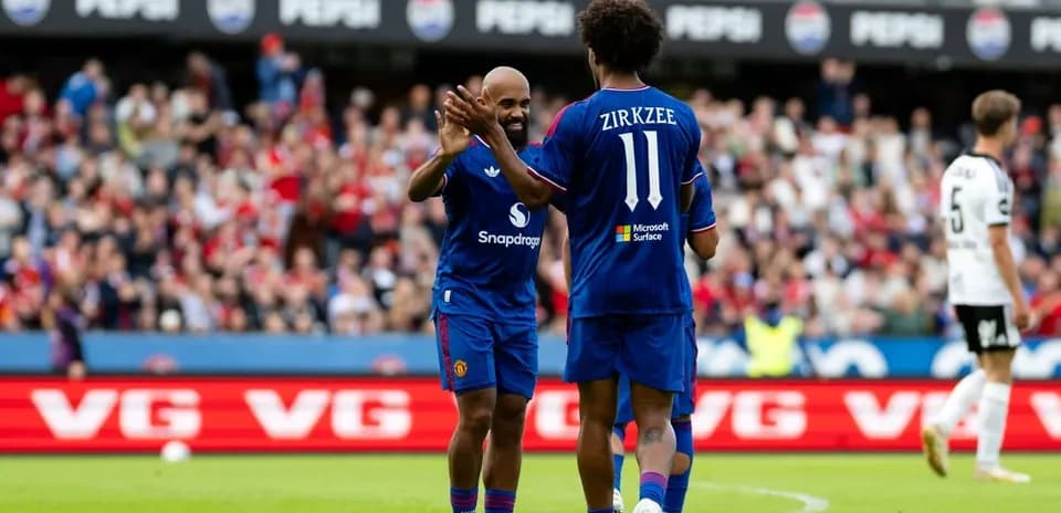 Two players celebrating on the pitch during match