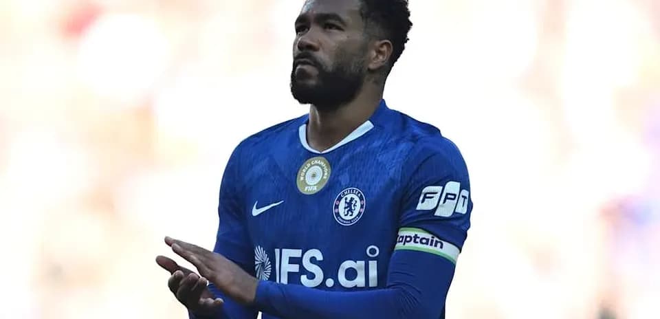 Player in blue jersey applauding fans during match