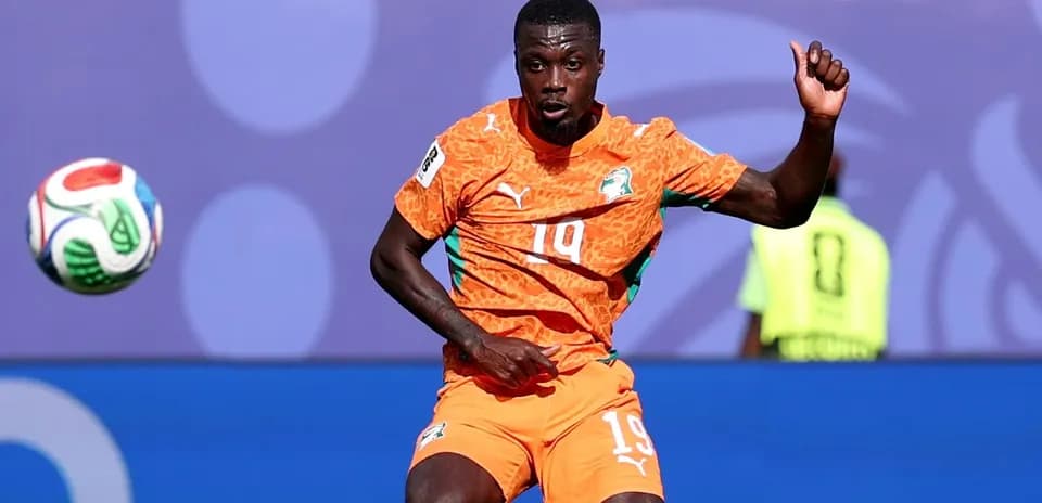 Player in orange kit controlling a soccer ball