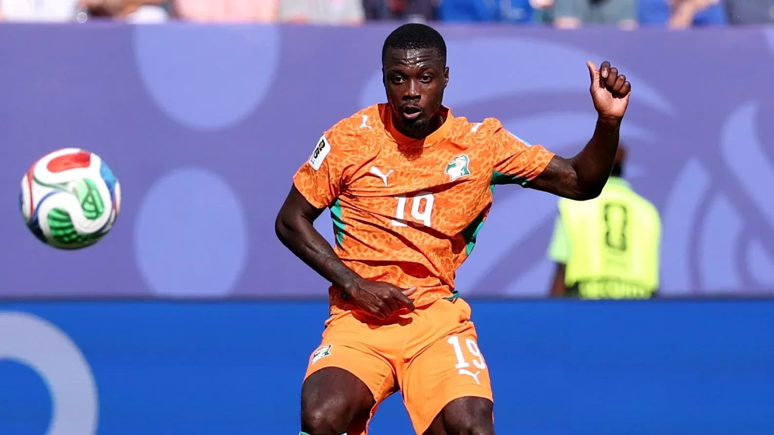 Player in orange kit controlling a soccer ball