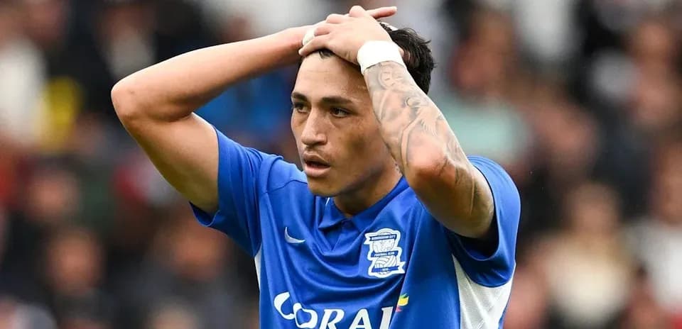 Player in blue jersey holding head in frustration