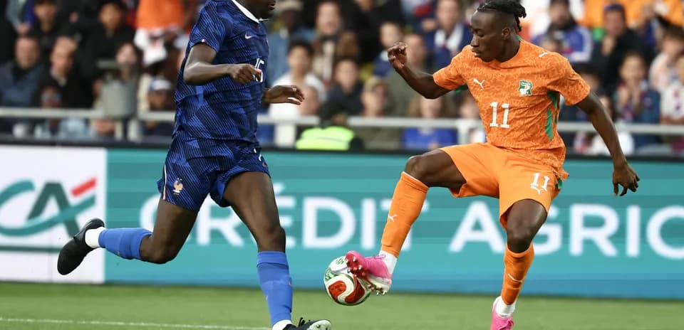 Player in orange dribbling past defender in blue