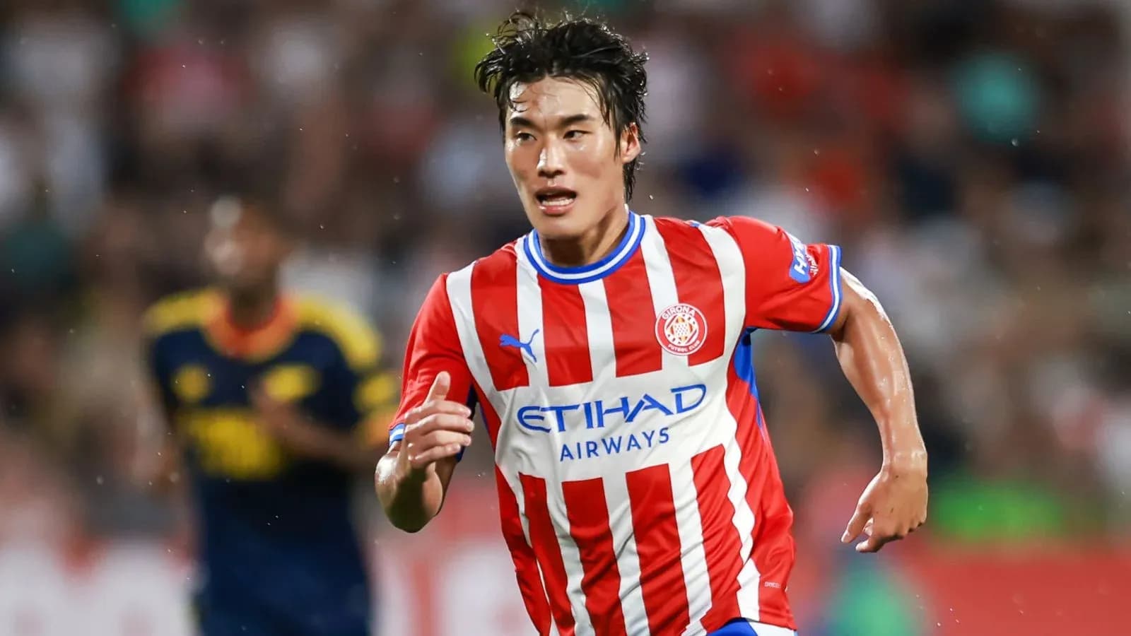 Player running with the ball in Girona kit