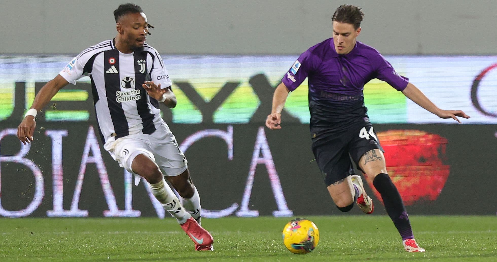 Juventus player challenges Fiorentina opponent for the ball
