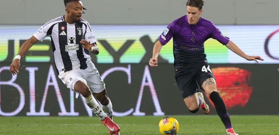 Juventus player challenges Fiorentina opponent for the ball