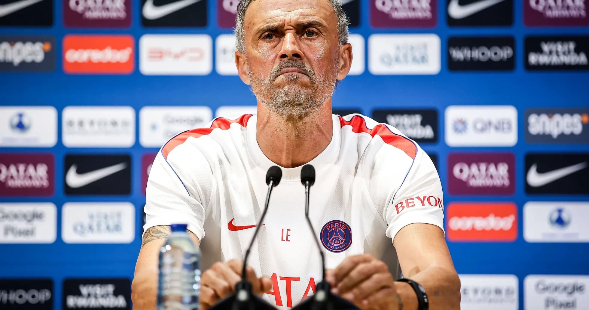 Manager at press conference with team logo backdrop