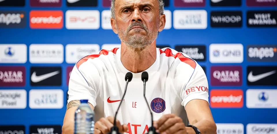 Manager at press conference with team logo backdrop