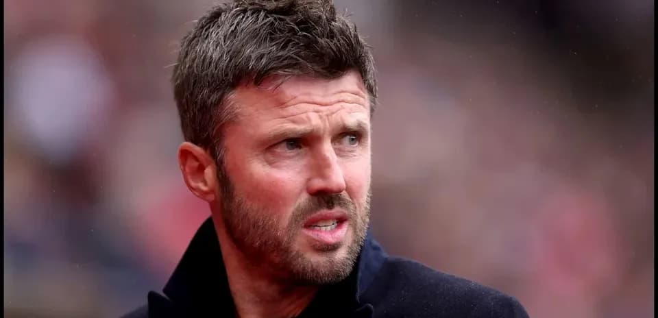 Man in black coat at a football match