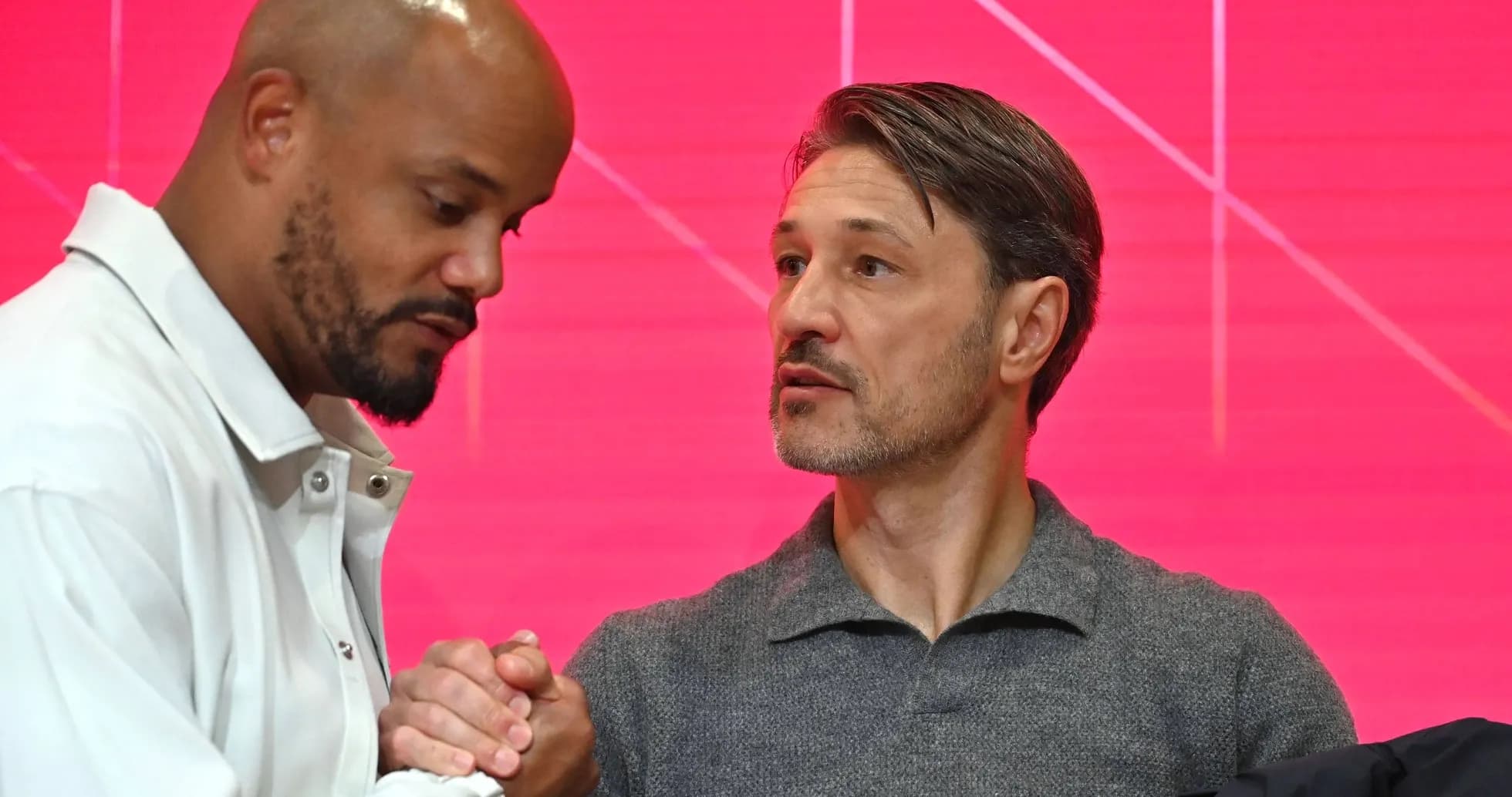 Two men shaking hands at press event