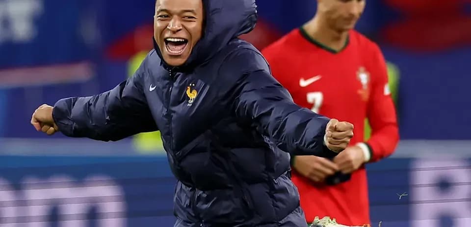 Kylian Mbappé celebrating in warm-up jacket during match