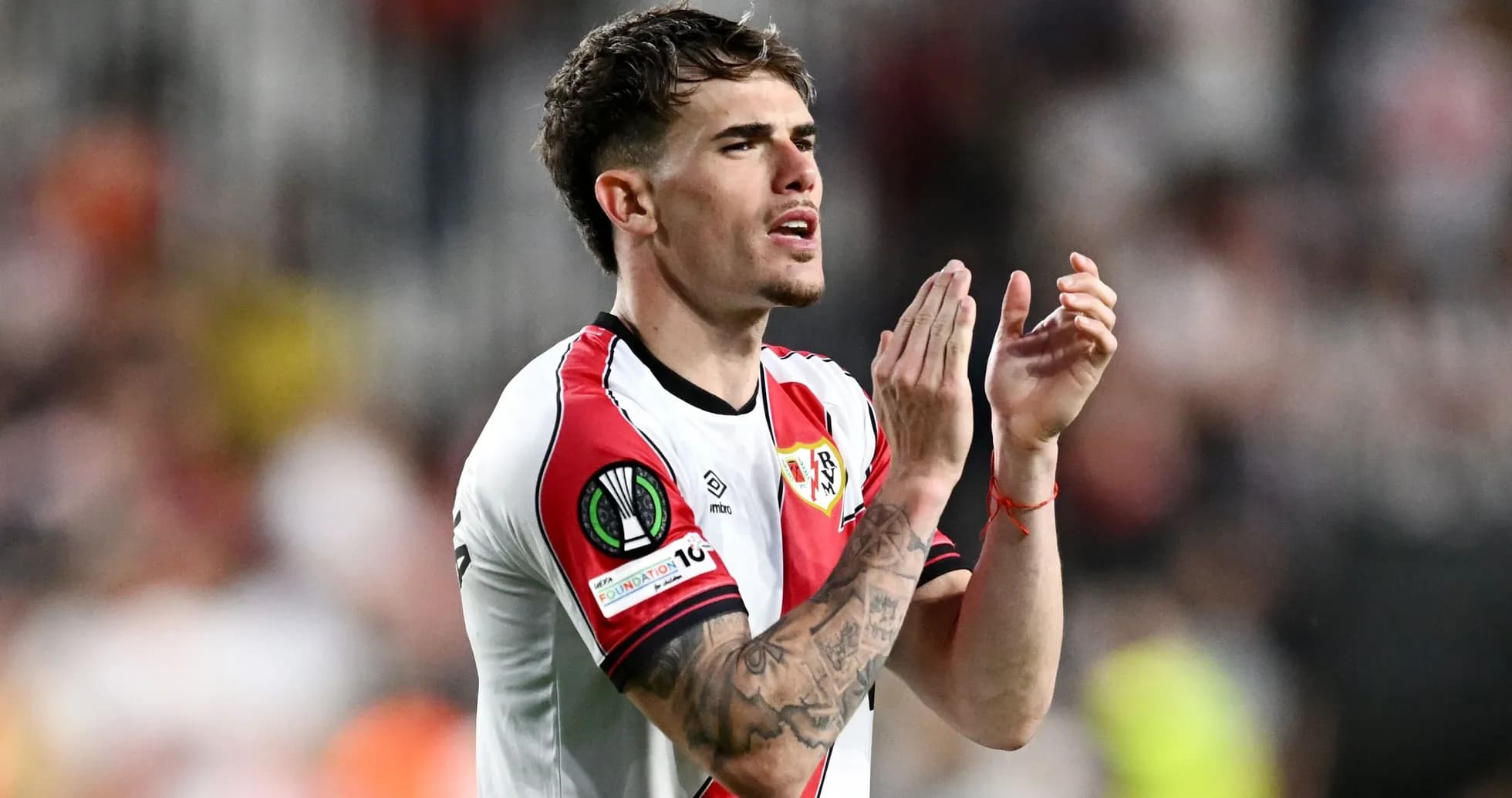 Player clapping in Rayo Vallecano jersey on field