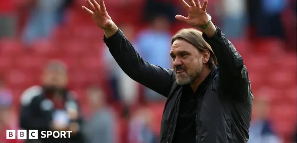 Manager gesturing to crowd in stadium
