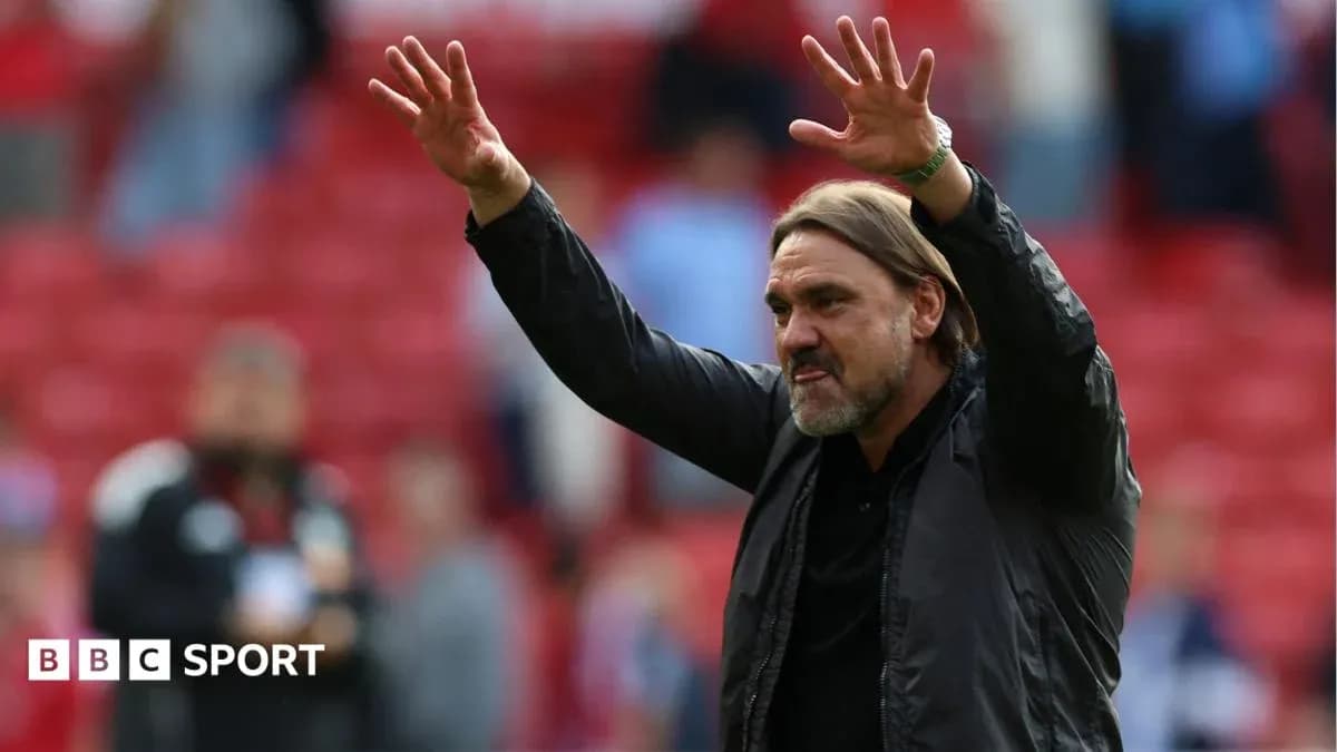 Manager gesturing to crowd in stadium
