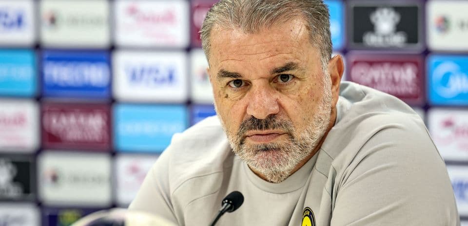 Manager at press conference with microphone and ball