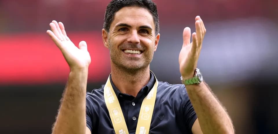 Manager celebrating with hands raised and medal