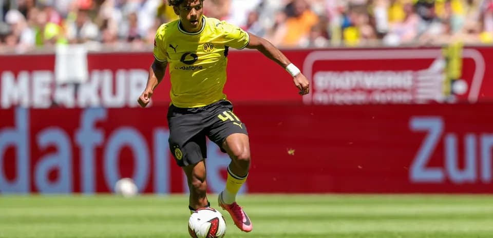 Player in yellow kit dribbling the ball on field