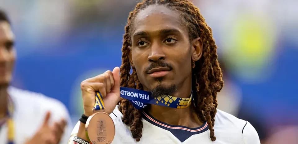 Player holding FIFA World Cup bronze medal proudly