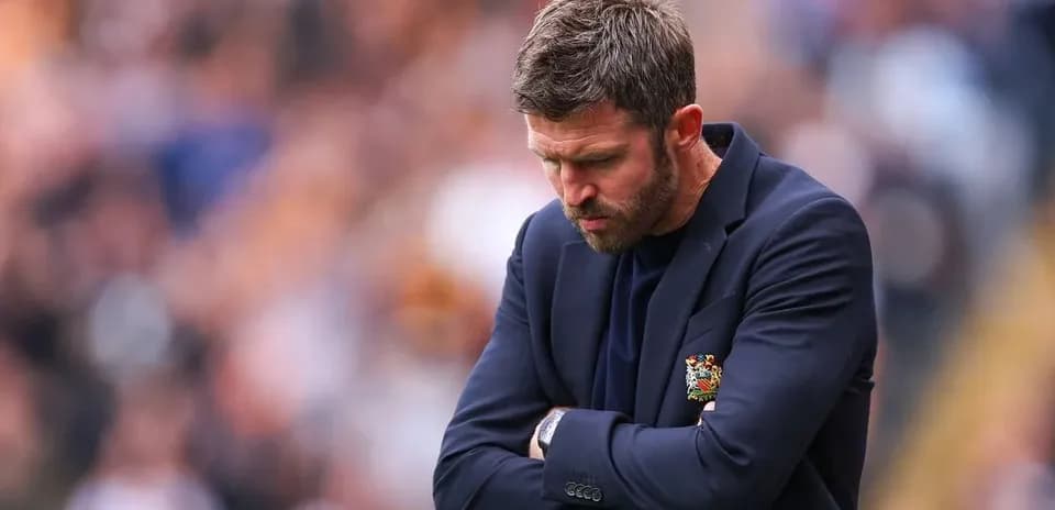 Coach with arms crossed, looking down in disappointment
