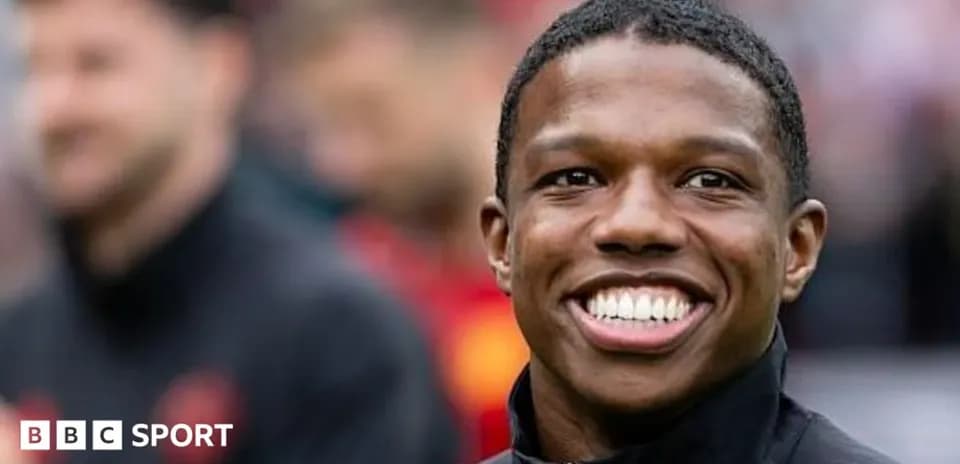 Smiling player in black jacket on field