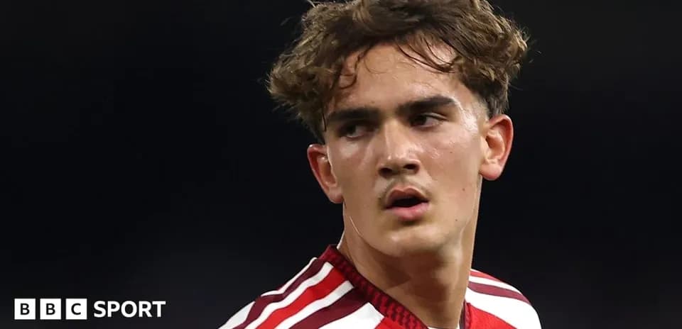 Young footballer in red jersey during match