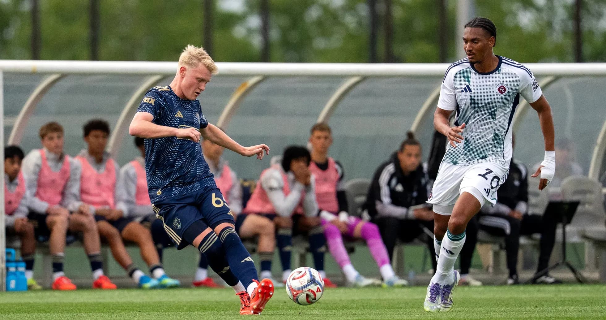 New England II player kicking the ball