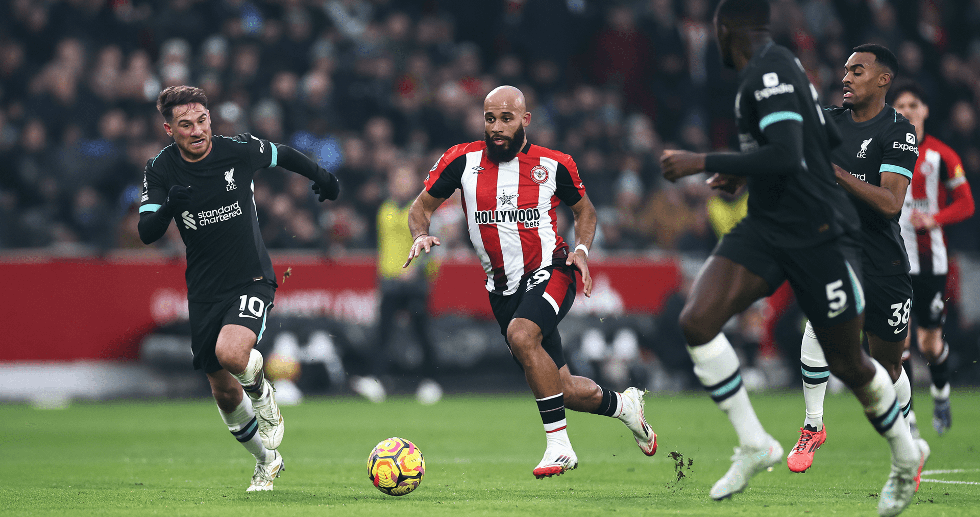 Liverpool player chasing Brentford opponent with ball