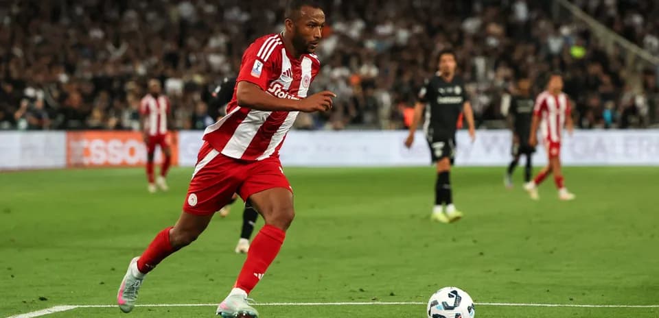 Player in red and white sprinting towards the ball