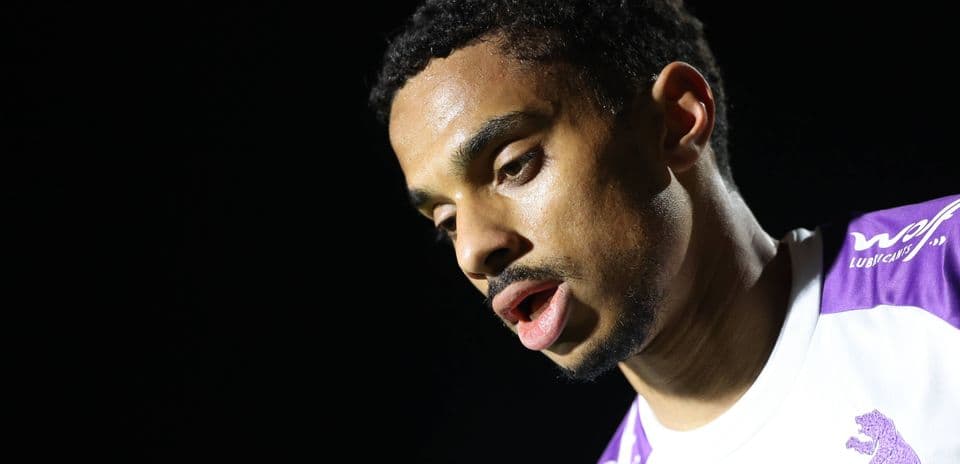Player looking down, wearing a white jersey