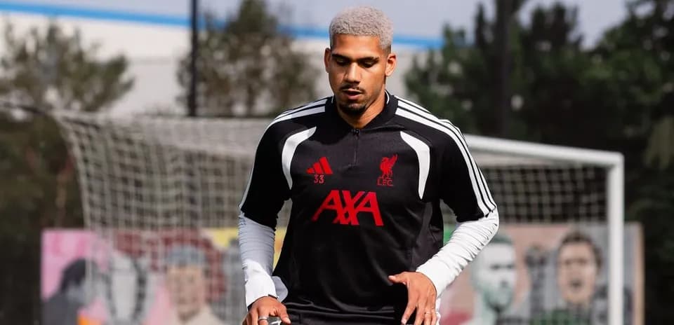 Player training on pitch wearing Liverpool kit