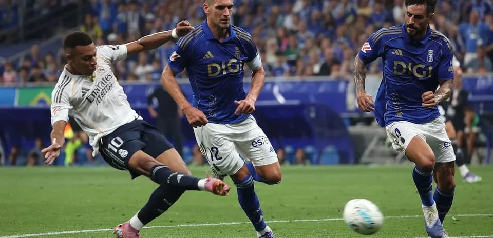 Real Madrid player attempting a shot against Oviedo