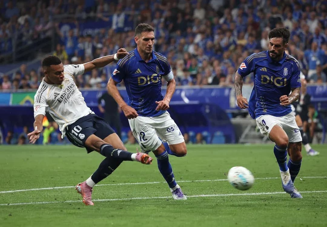 Real Madrid player attempting a shot against Oviedo