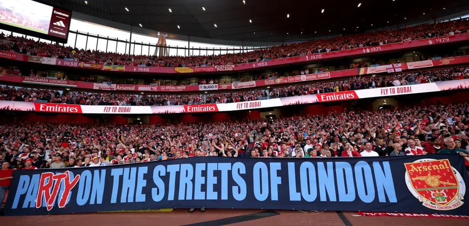 Arsenal fans celebrating with a large banner