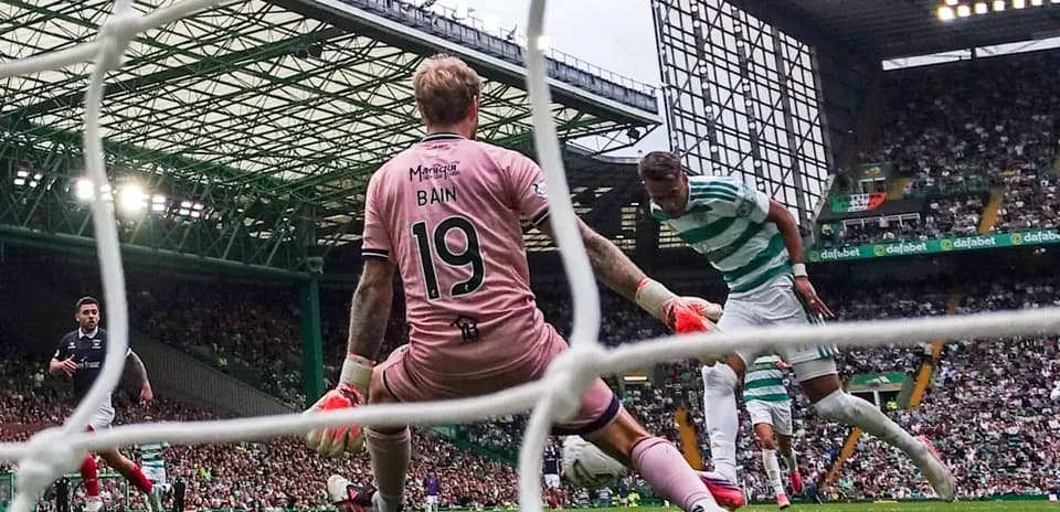Celtic player attempting to score against goalkeeper Bain
