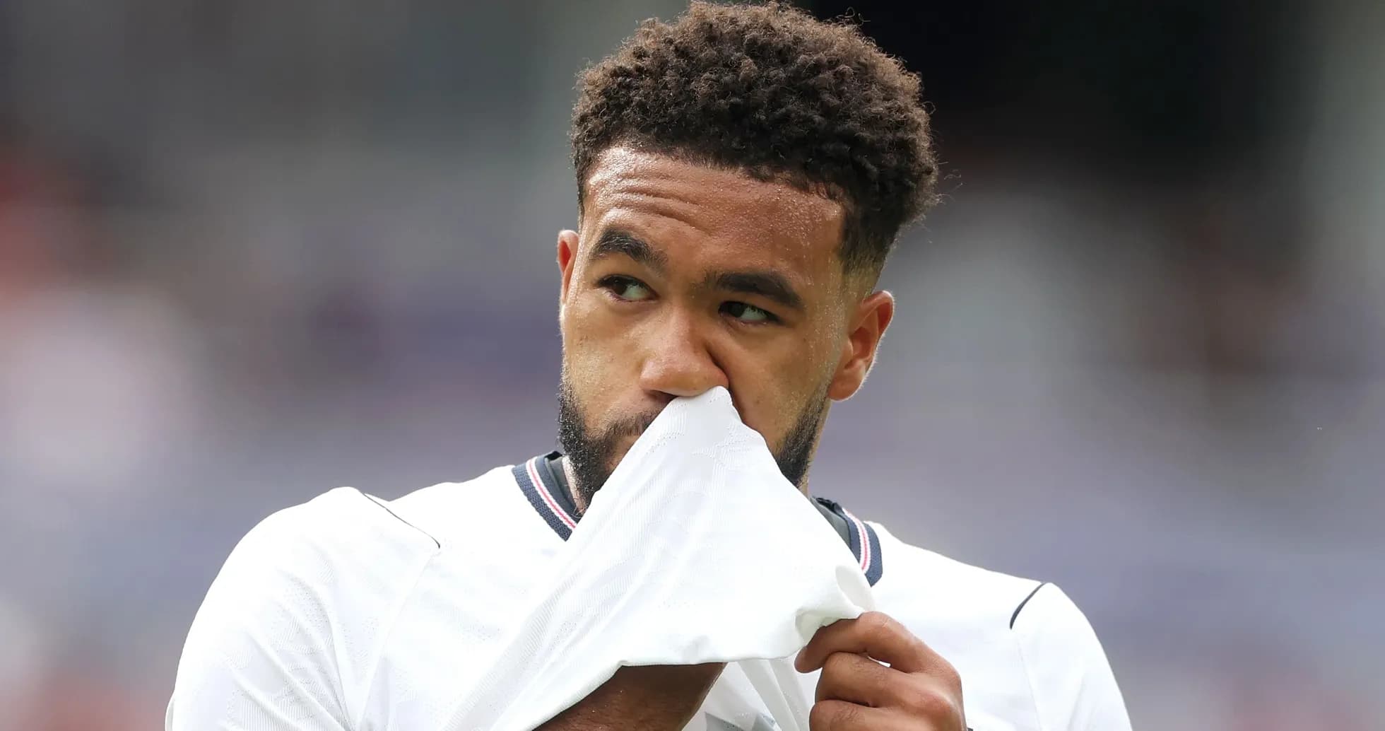 Player holding shirt while looking thoughtful