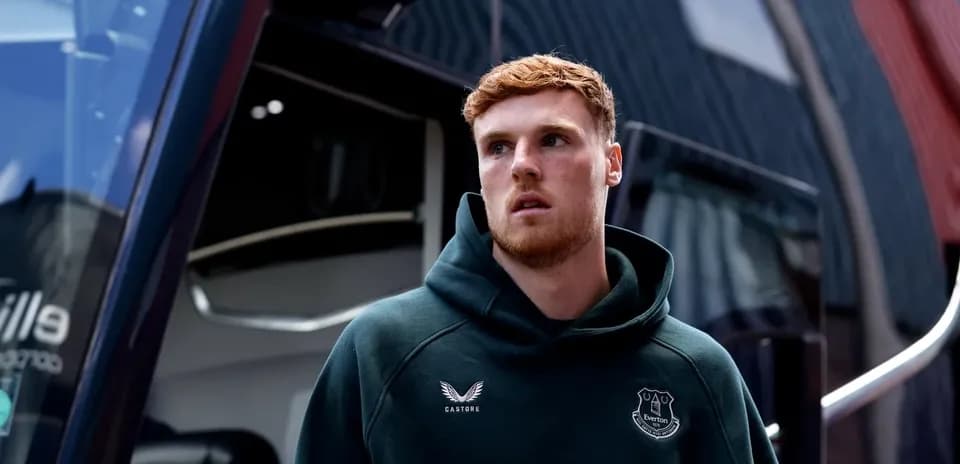 Player in Everton hoodie near team bus