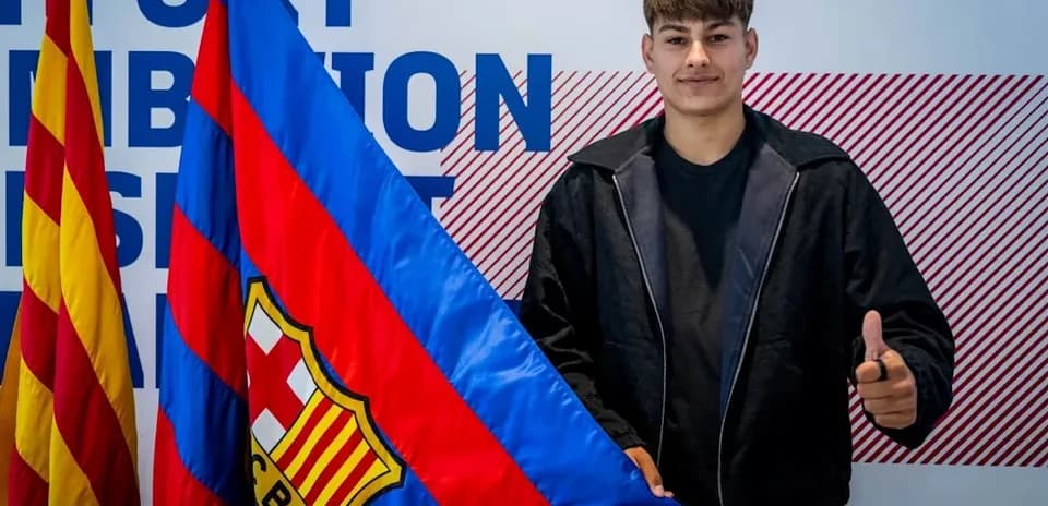 Player posing with FC Barcelona flag during signing event