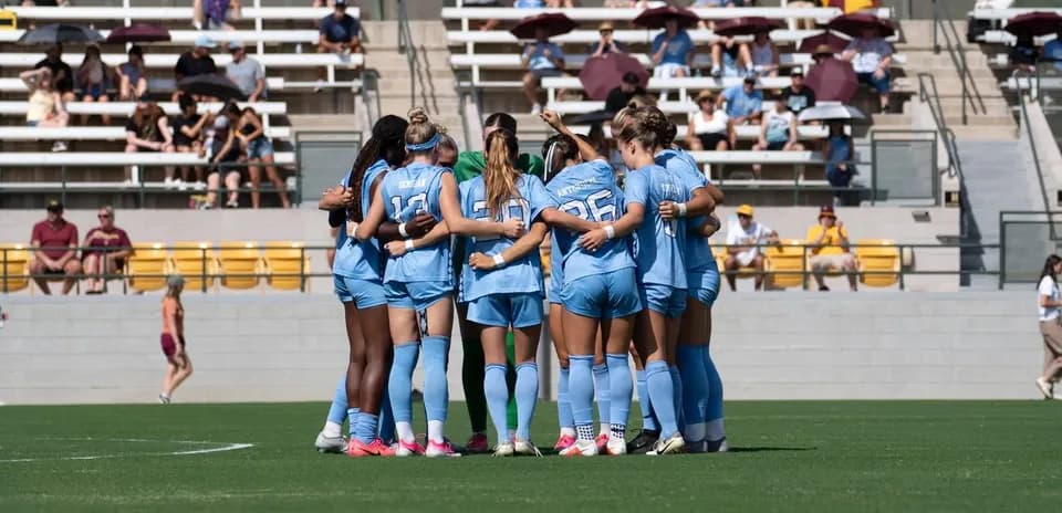 Women's soccer team huddled before the match