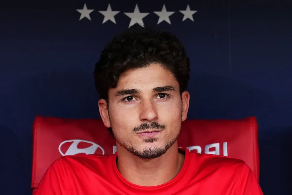 Player seated on bench in red team jersey