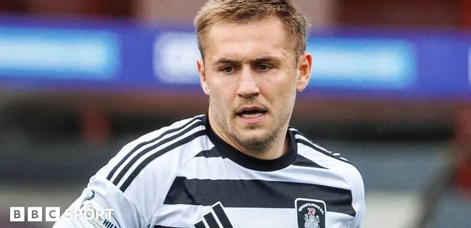 Player in black and white striped jersey on field