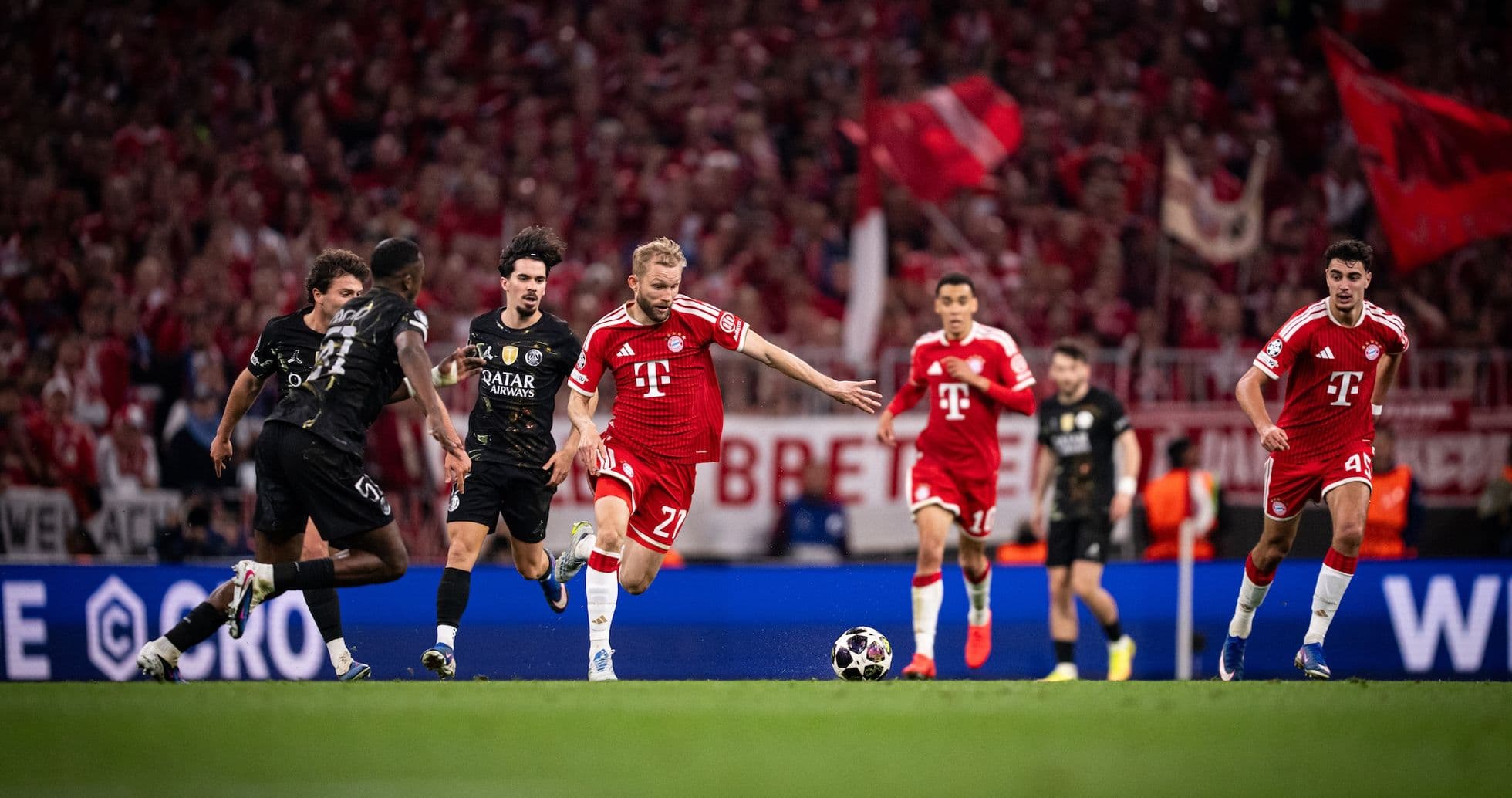 Bayern player dribbling against PSG defenders