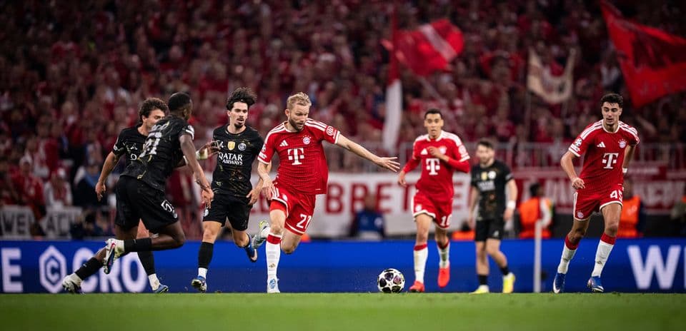 Bayern player dribbling against PSG defenders