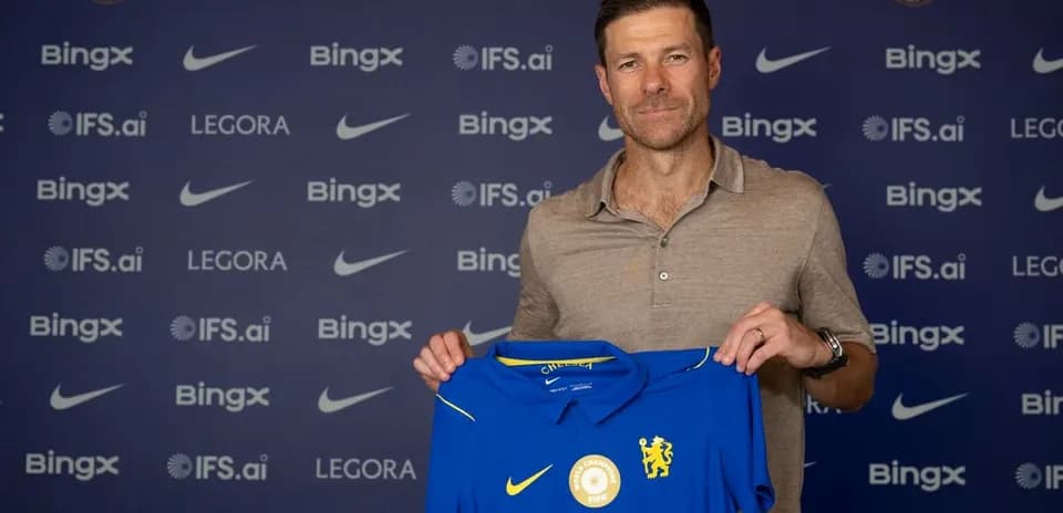 New manager holding Chelsea jersey at press conference