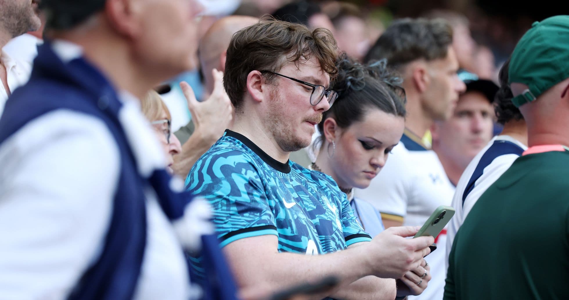 Fans watching a match, some using smartphones