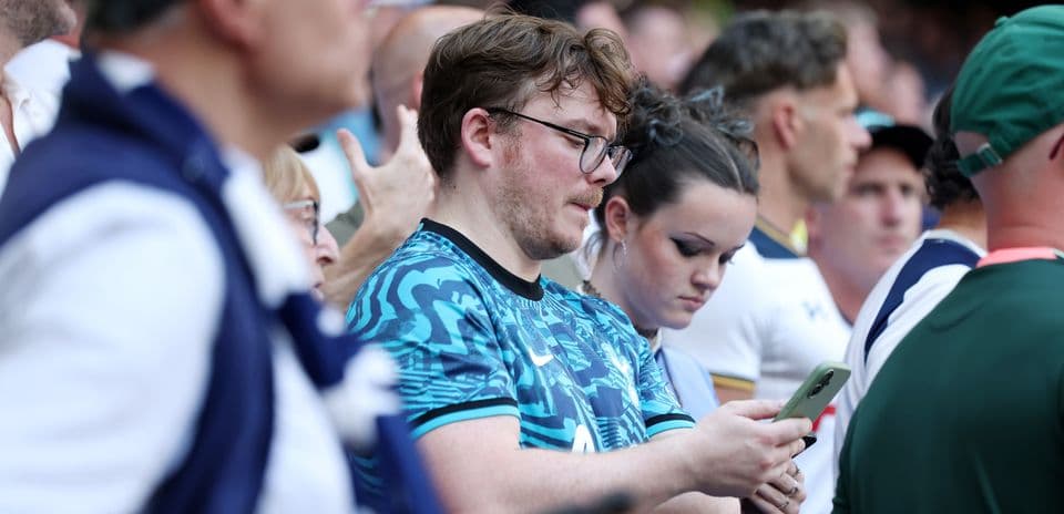 Fans watching a match, some using smartphones