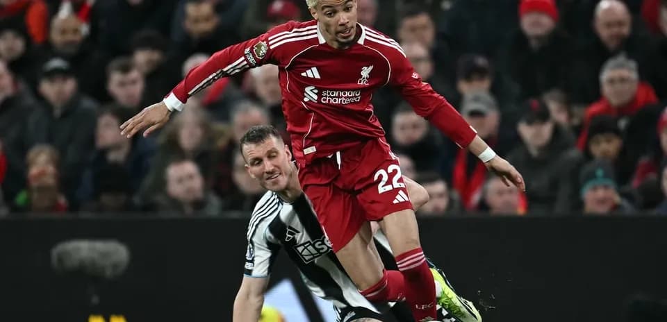 Liverpool player tackling Newcastle opponent