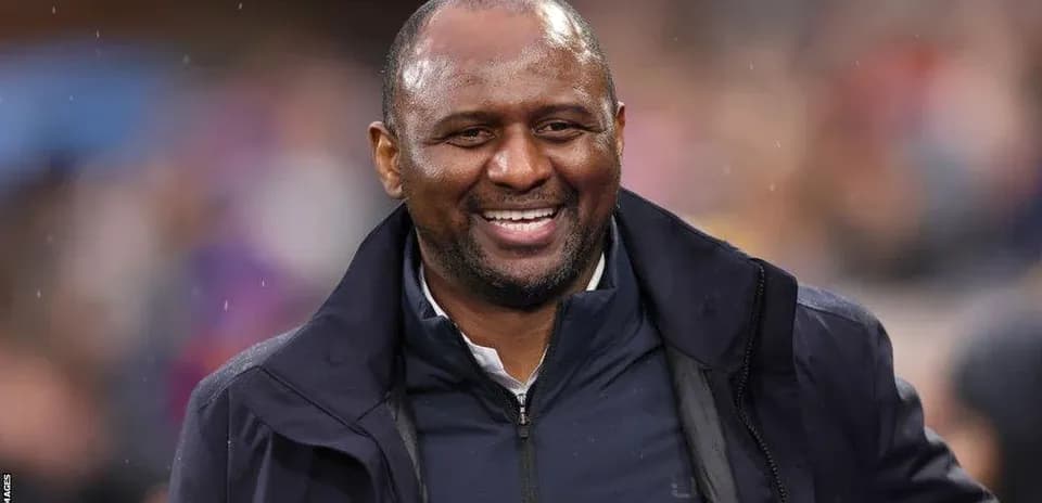 Coach smiling on the sidelines during a match