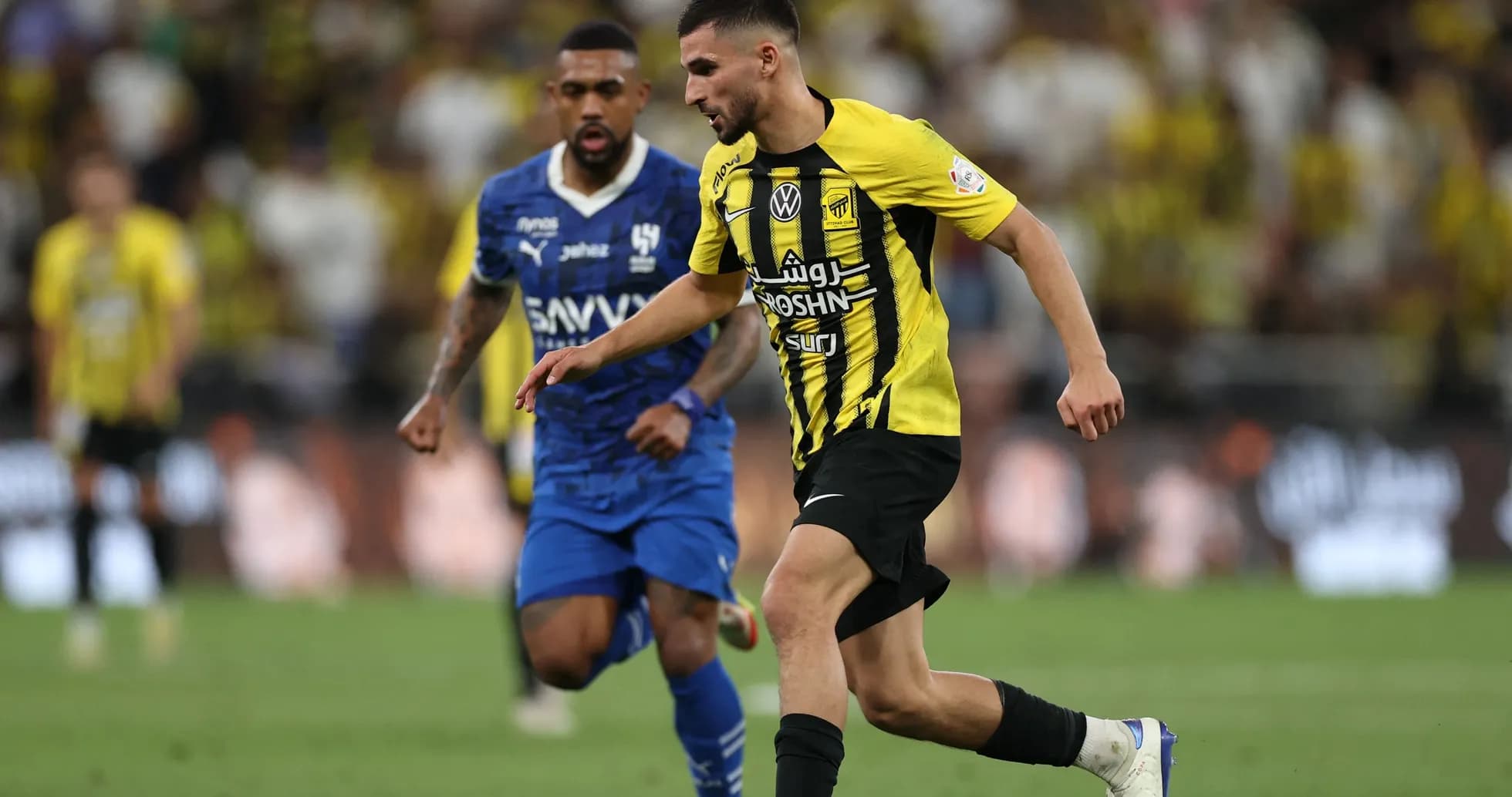 Player in yellow jersey dribbling past opponent in blue