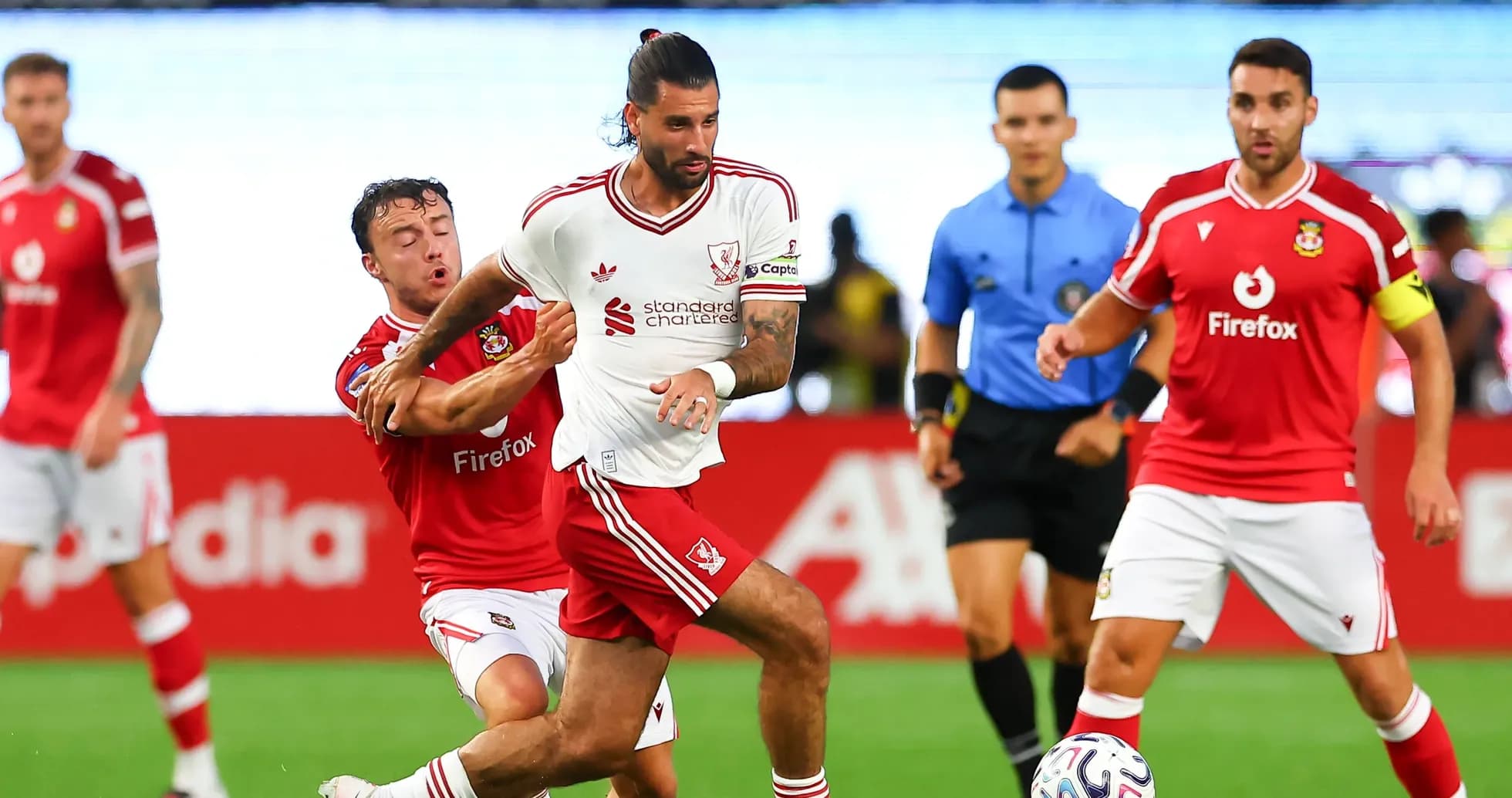 Player in white shirt dribbling past opponent in red
