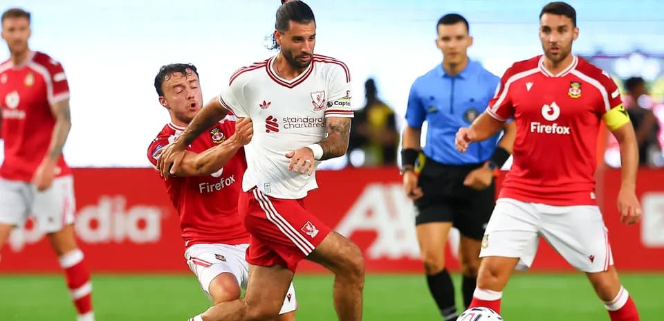 Player in white shirt dribbling past opponent in red