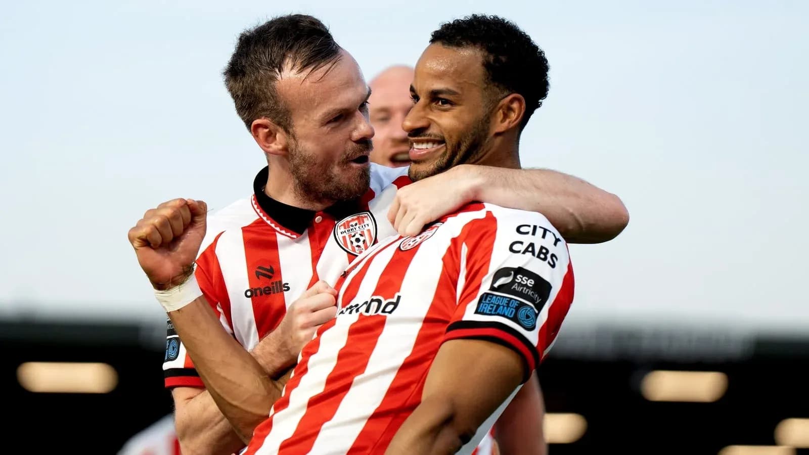 Two players celebrating a goal in team jerseys